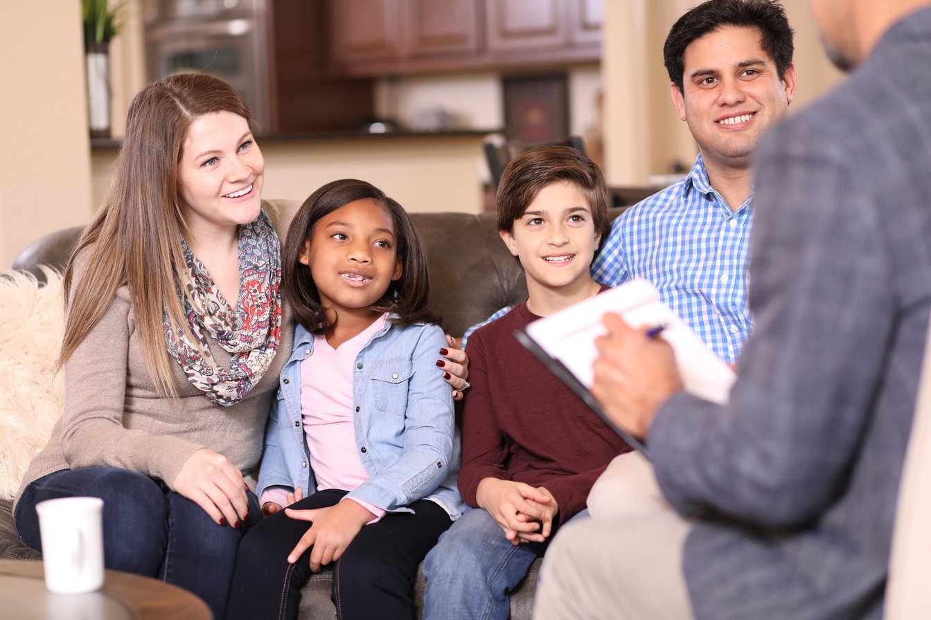 Family counseling session at home with therapist.